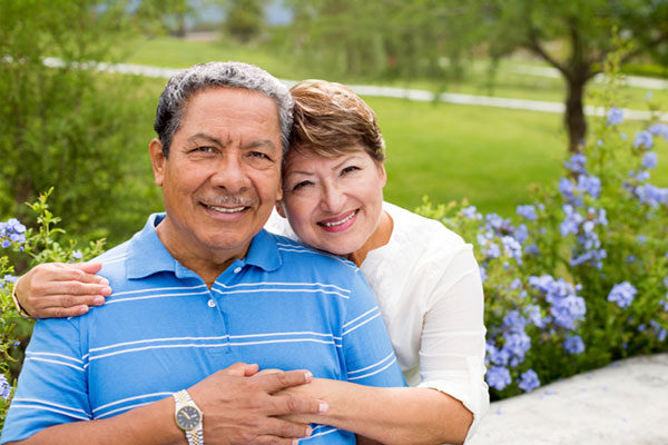 two elderly couples smiling at the camera together